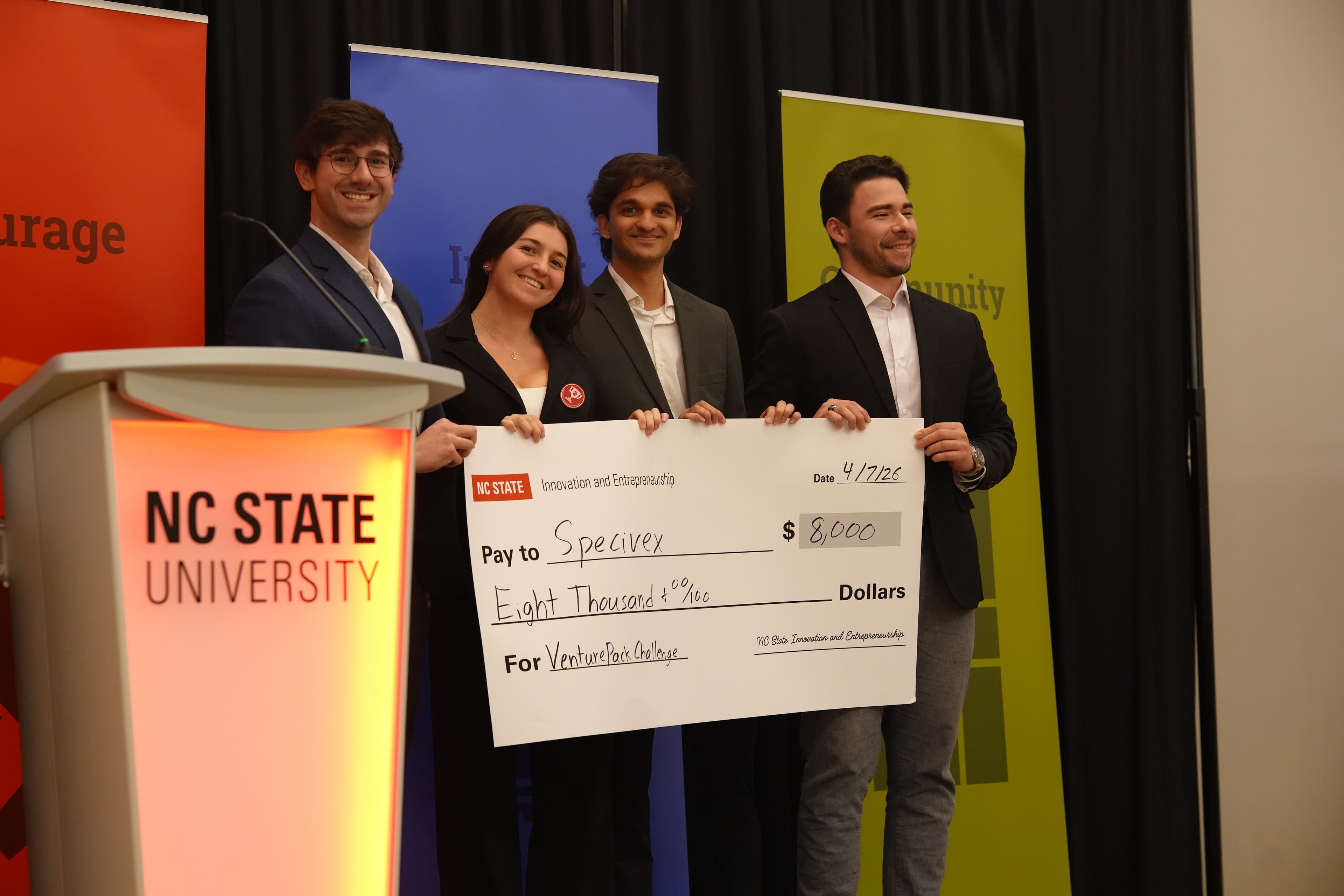 Student team holding a large check for $8,000